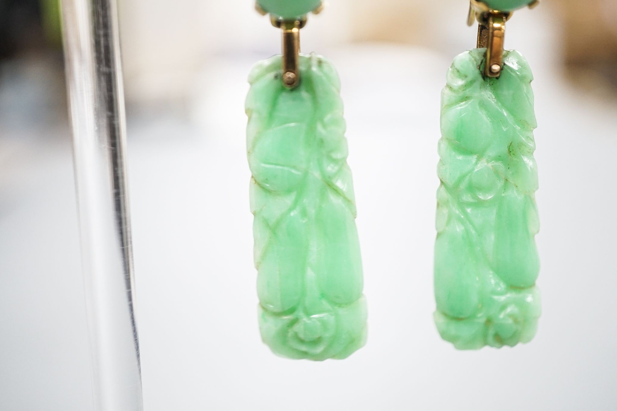 A pair of yellow metal mounted carved jade drop earrings, 43mm, gross 6.8 grams.
